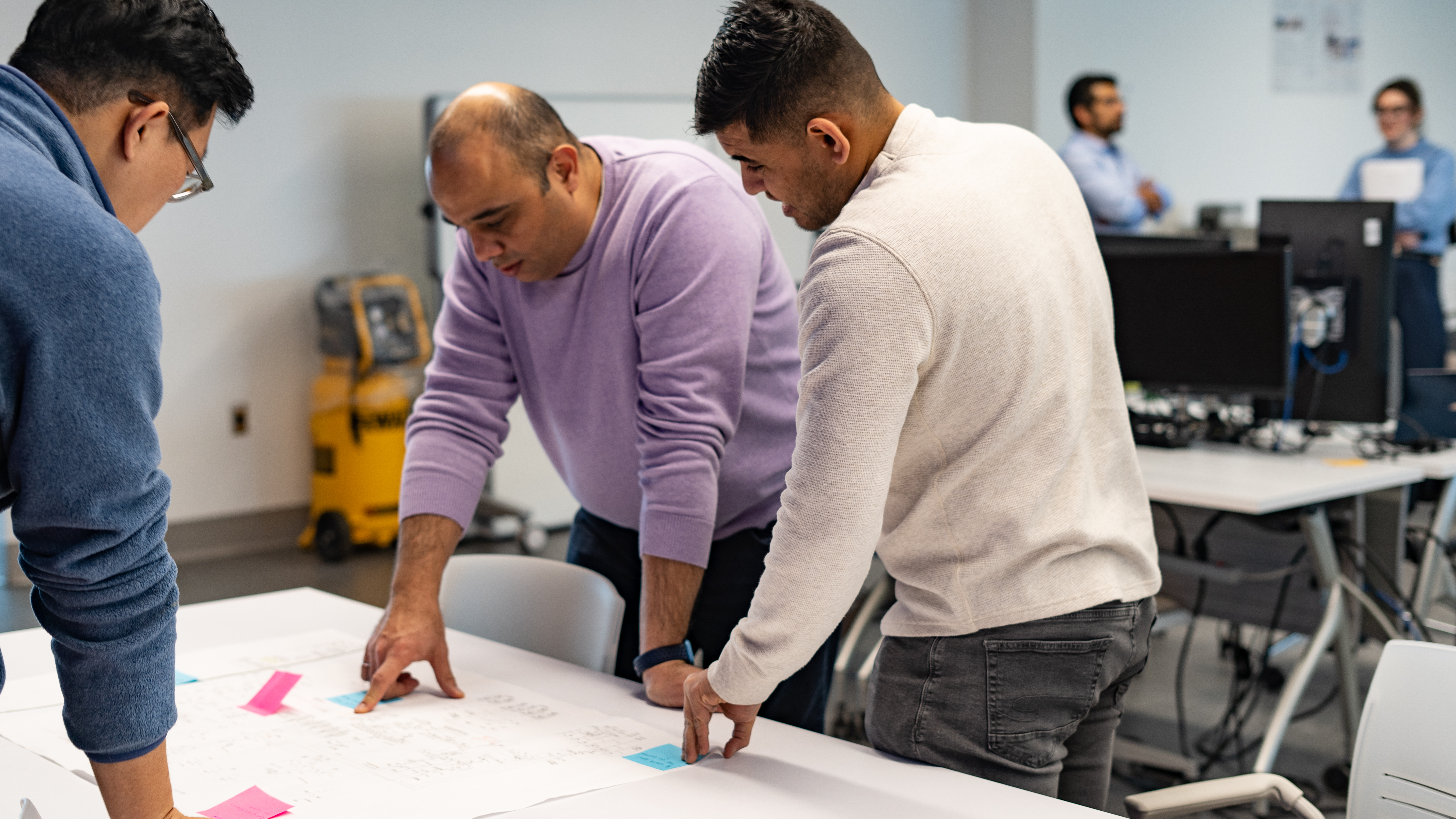 Team collaborating over project plans at Mohawk College